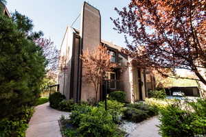 View of side of property with a balcony, stucco siding, and a chimney