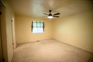 Unfurnished room featuring carpet and ceiling fan