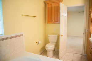 Full bath with light tile patterned flooring, a garden tub, and vanity