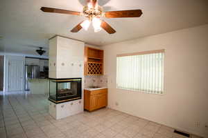 Kitchen with backsplash, light tile patterned floors, light countertops, and stainless steel appliances