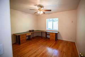 Unfurnished office featuring light wood-style flooring and a ceiling fan