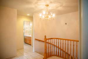 Stairs featuring tile patterned flooring, a chandelier, and recessed lighting
