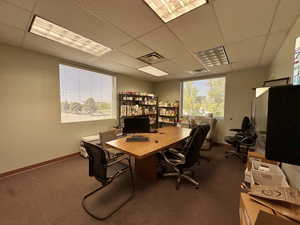 Office featuring a paneled ceiling and dark carpet