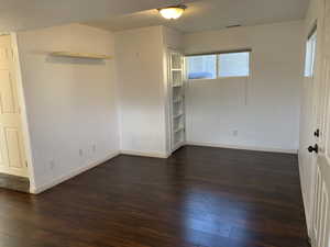 Spare room featuring dark wood finished floors