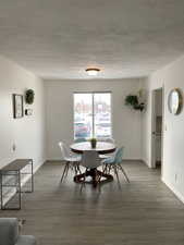 Dining space featuring light wood-style floors and a textured ceiling