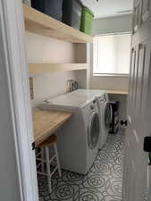 Laundry room with washing machine and dryer and light tile patterned flooring