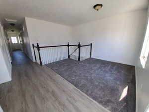 Additional living space featuring baseboards and wood finished floors