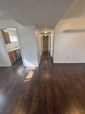 Hall featuring dark wood-type flooring and baseboards