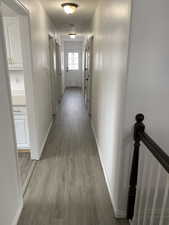 Hallway featuring light wood-type flooring and baseboards