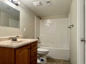 Full bathroom featuring shower / washtub combination, vanity, and a textured wall