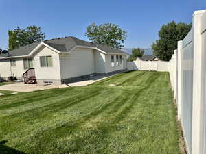 Rear view of house featuring a patio area, a fenced backyard, and a mountain view