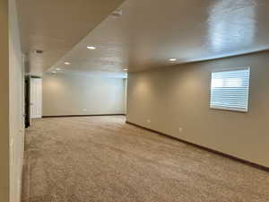 Huge family room with light colored carpet and recessed lighting all plumbed for a kitchen