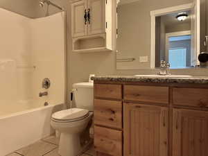 Bathroom featuring bathtub / shower combination, light tile patterned floors, and vanity
