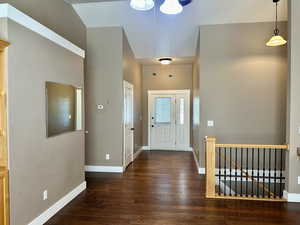 Inviting foyer with dark wood-style floors and easy access to the downstairs and upstairs