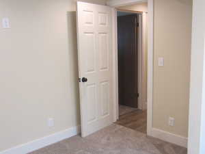 Spare room featuring carpet and baseboards
