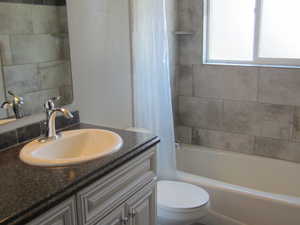 Bathroom with vanity and shower / bathtub combination with curtain
