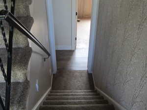 Stairway with baseboards and carpet flooring