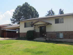 View of front of home featuring a front lawn, brick siding, and a shingled roof