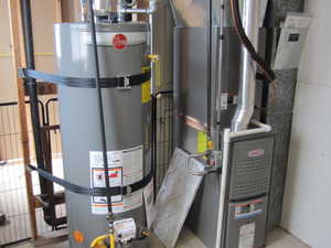Utility room featuring water heater and heating unit