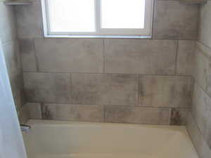 Bathroom featuring healthy amount of natural light and bathtub / shower combination