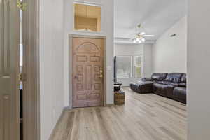 Entrance foyer featuring light wood-type flooring, lofted ceiling, and ceiling fan