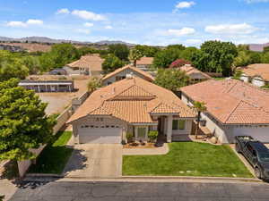 View of front of home with an attached garage, a residential view, driveway, and a mountain view