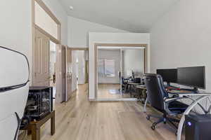 Office area featuring light wood-style flooring and lofted ceiling