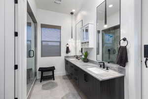 Full bathroom with double vanity and a shower stall
