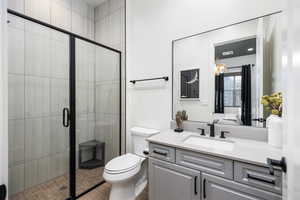 Full bathroom featuring a shower stall, vanity, and ensuite bathroom