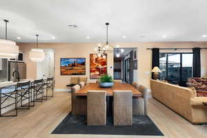 Dining room with a chandelier, recessed lighting, and light wood-style flooring