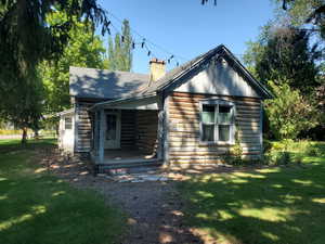 View of front of property with a front lawn, a chimney, and a shingled roof