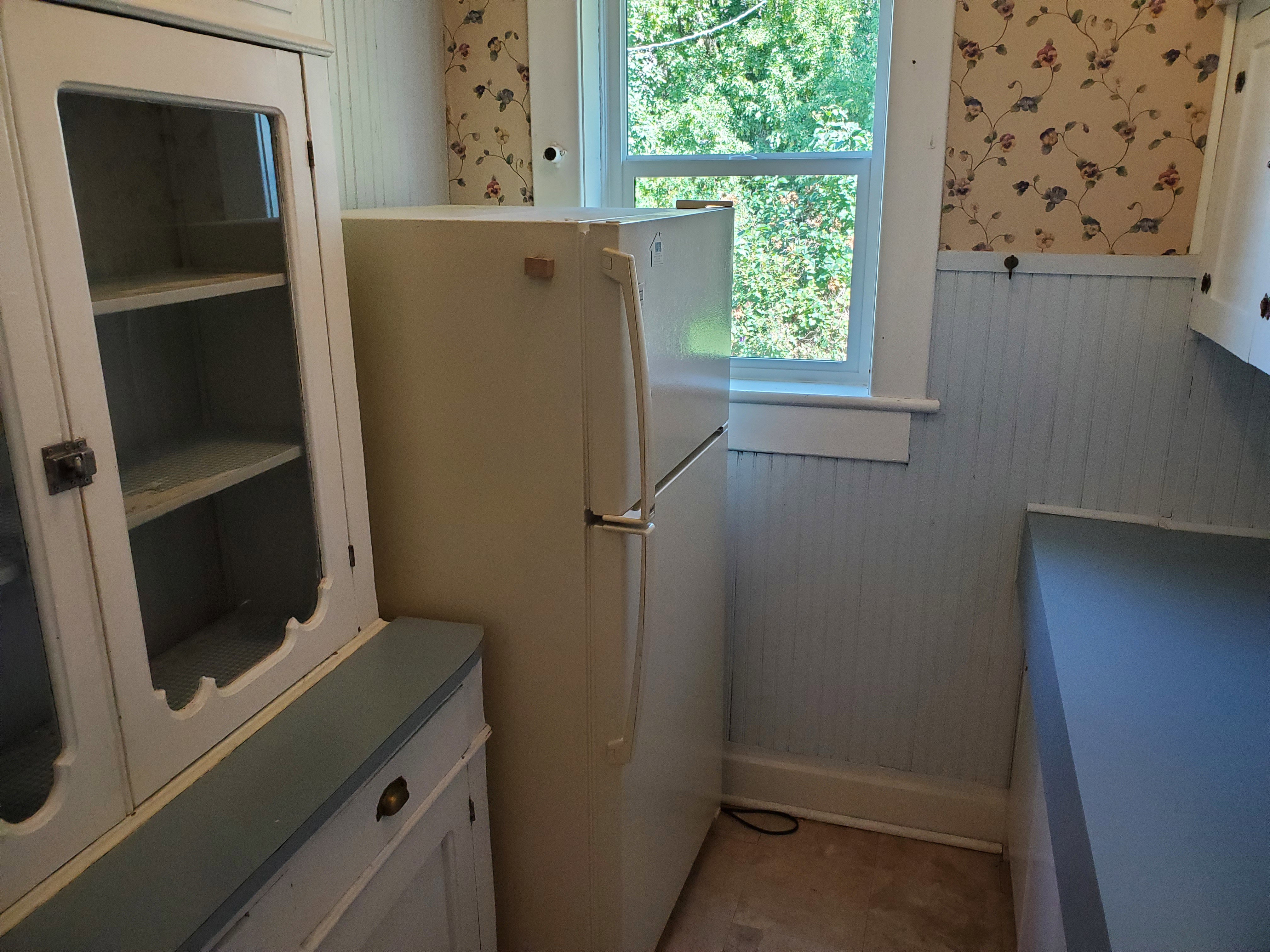 Laundry area featuring wallpapered walls and a wainscoted wall
