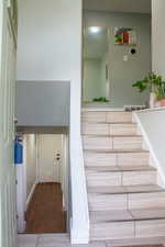 Stairway with wood finished floors and baseboards