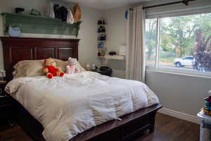 Bedroom featuring dark wood-type flooring and baseboards