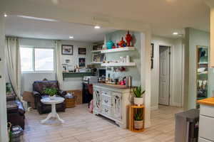 Kitchen featuring wood finish floors, recessed lighting, wood counters, open shelves, and white cabinetry