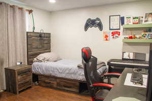 Bedroom featuring wood finished floors and an office area