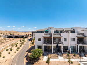 Front of property featuring stone siding, a balcony, stucco siding, and a mountain view