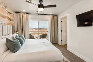 Bedroom with carpet flooring, access to outside, a textured ceiling, and a ceiling fan