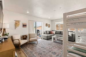Living room featuring light wood-style flooring, a textured ceiling, and recessed lighting