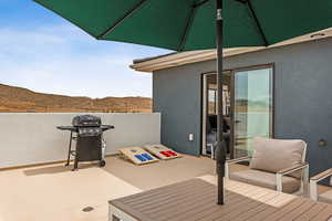 View of patio with a mountain view and area for grilling