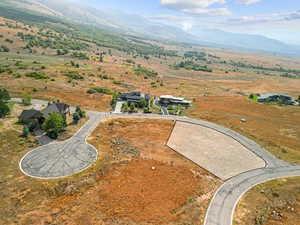Aerial view of property and surrounding area with a mountain backdrop