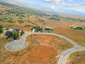Aerial view of property and surrounding area with a mountainous background