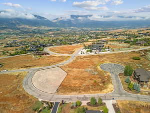 Aerial view of property and surrounding area featuring a mountainous background