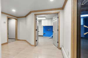 Hallway with crown molding, light wood-style floors, recessed lighting, and a baseboard heating unit