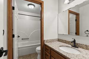 Bathroom with vanity, light tile patterned floors, and bathing tub / shower combination