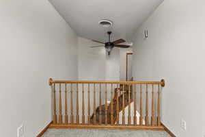 Stairs with baseboards and a ceiling fan