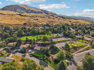 Aerial view of property and surrounding area with a mountain backdrop and nearby suburban area