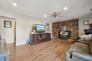 Living area with light wood-type flooring, ceiling fan, and recessed lighting