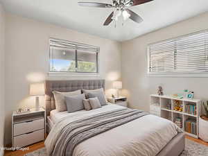 Bedroom with light wood-style floors and a ceiling fan