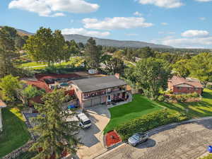 Aerial view of property and surrounding area with a mountainous background